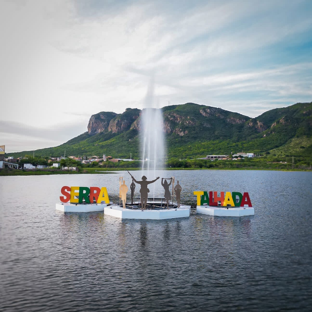 Monumento do Açude Borborema — letreiro SERRA TALHADA com sete dançarinos de xaxado e a Serra do Recreio ao fundo